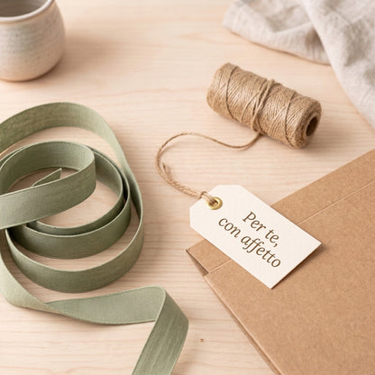 Dettaglio della personalizzazione della box regalo con nastro verde salvia e cartellino dedicato